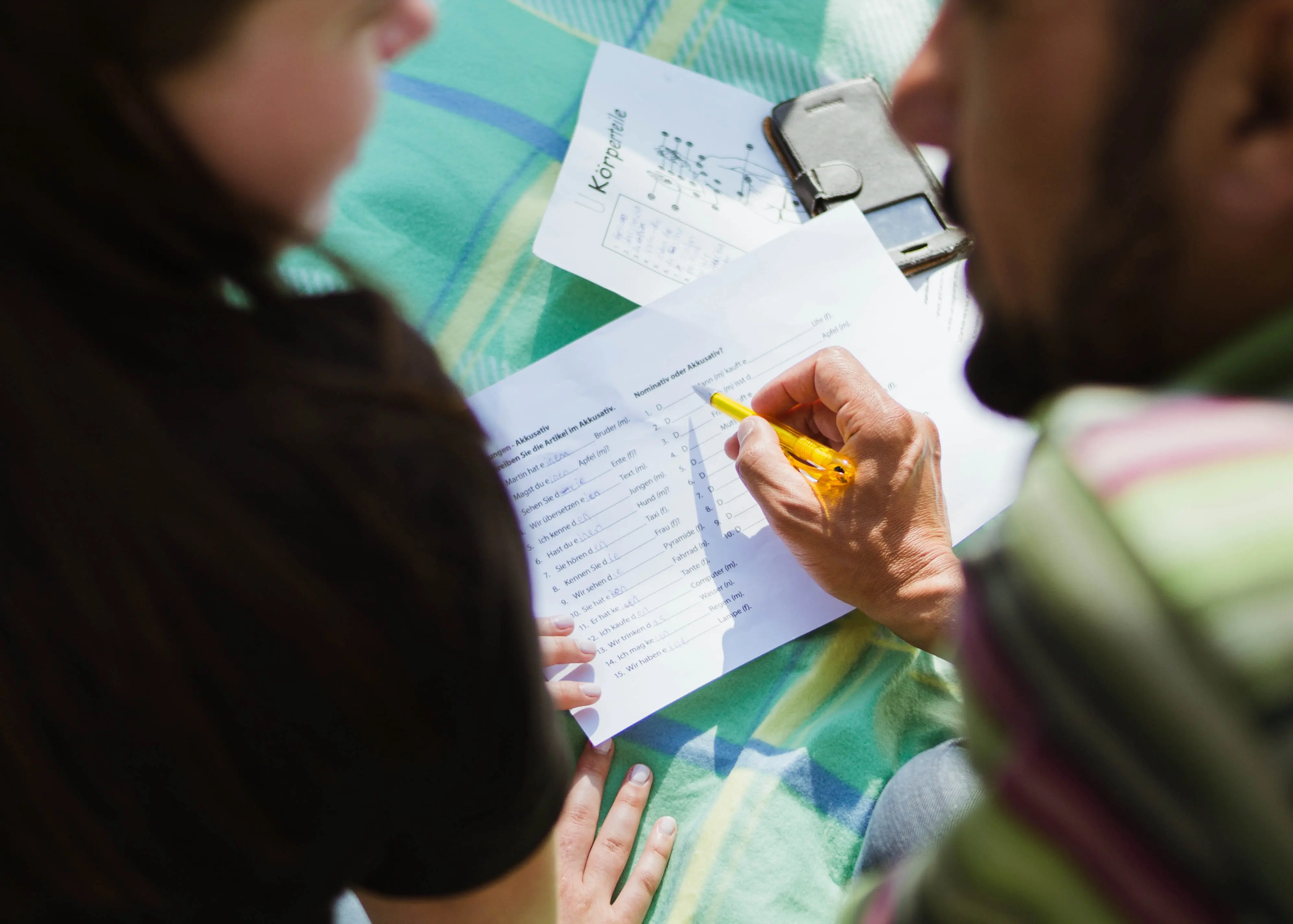 students-papers-phone-pencil-discussion-learning